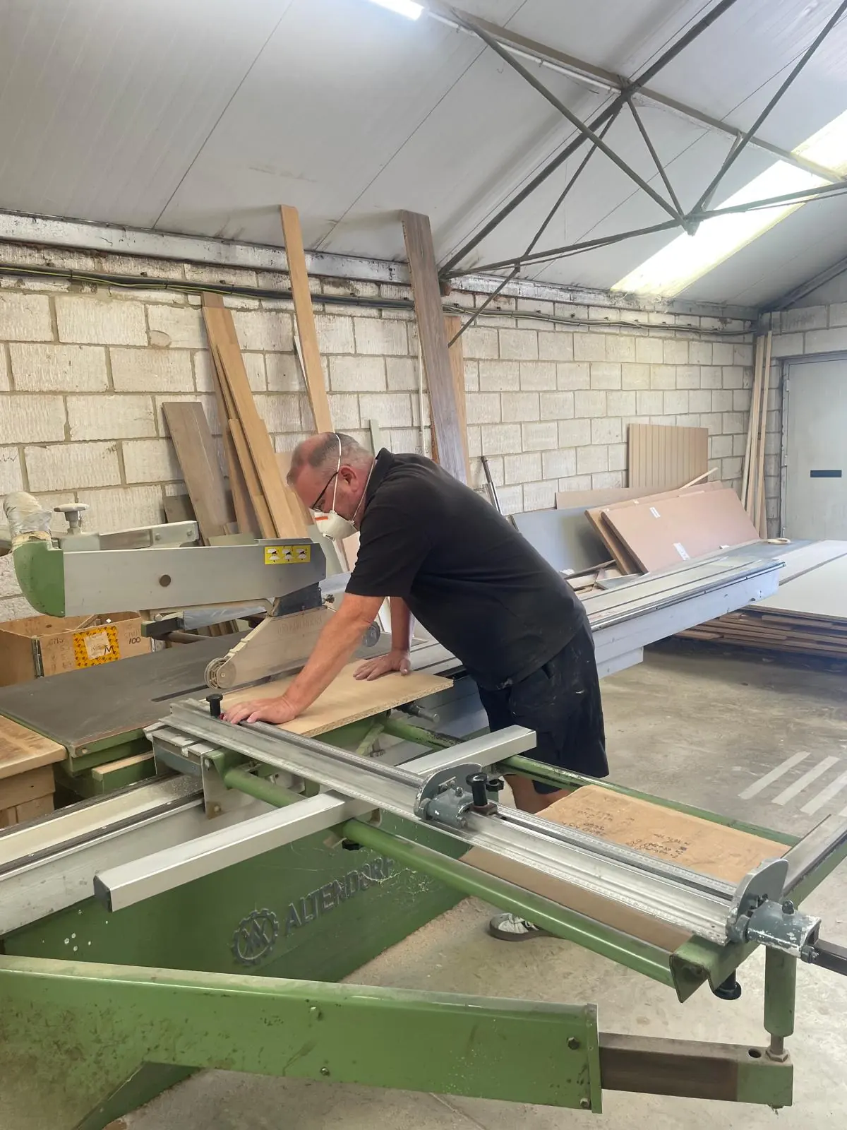 Sheet material being cut to size on the panel saw in the workshop