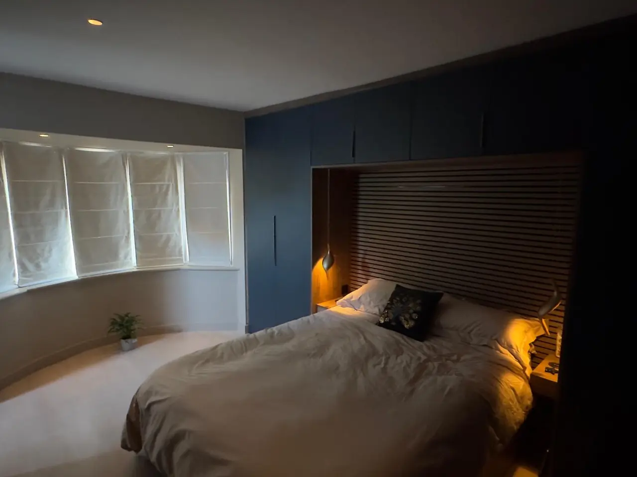 Bedroom navy fitted wardrobe bay window headboard, made and fitted by Sussex Design Interiors