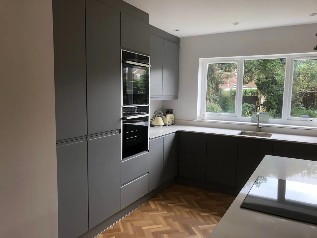 Kitchen anthracite tall units window garden, made and fitted by Sussex Design Interiors