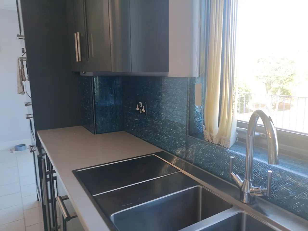 Kitchen blue glass mosaic splashback sink, made and fitted by Sussex Design Interiors