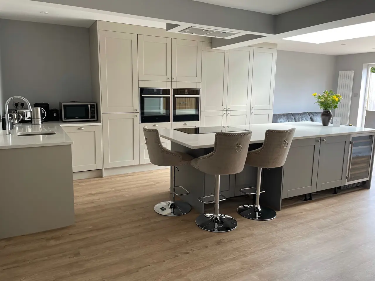 Cream shaker kitchen island with bar stools and a built-in wine cooler