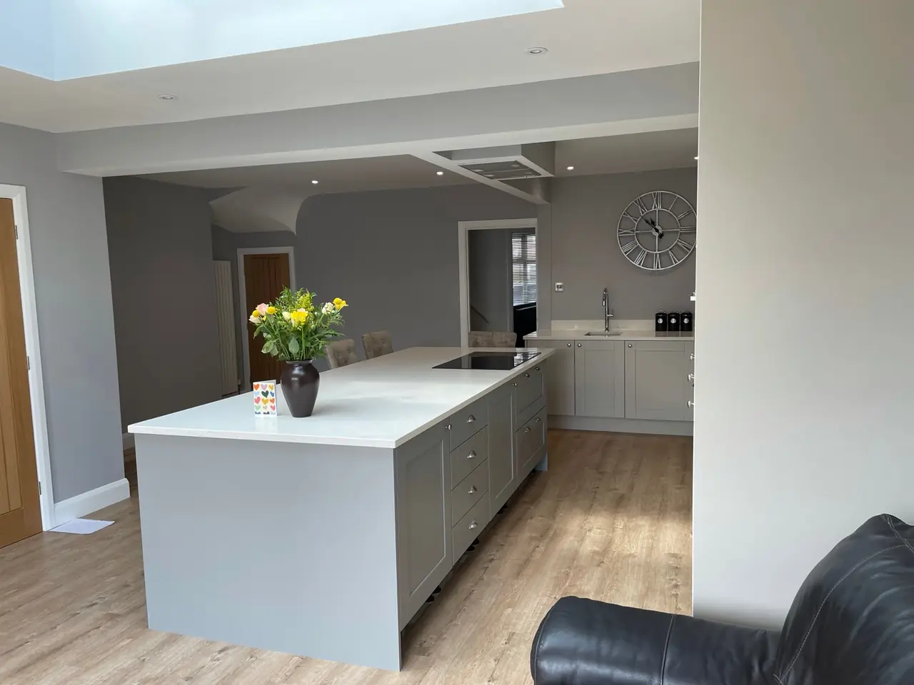 Grey shaker kitchen island lit by a skylight