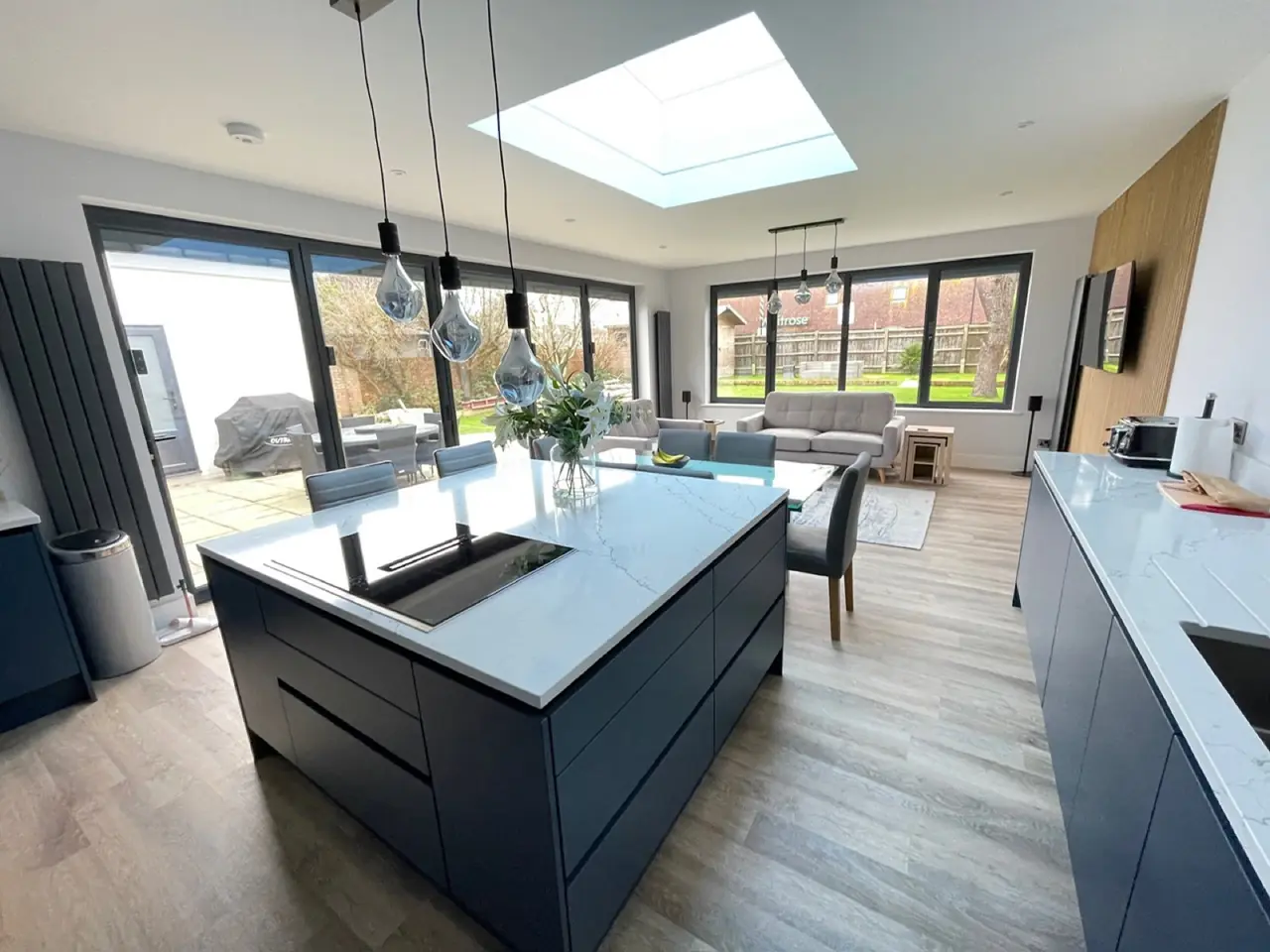 Kitchen navy blue island skylight dining area, made and fitted by Sussex Design Interiors
