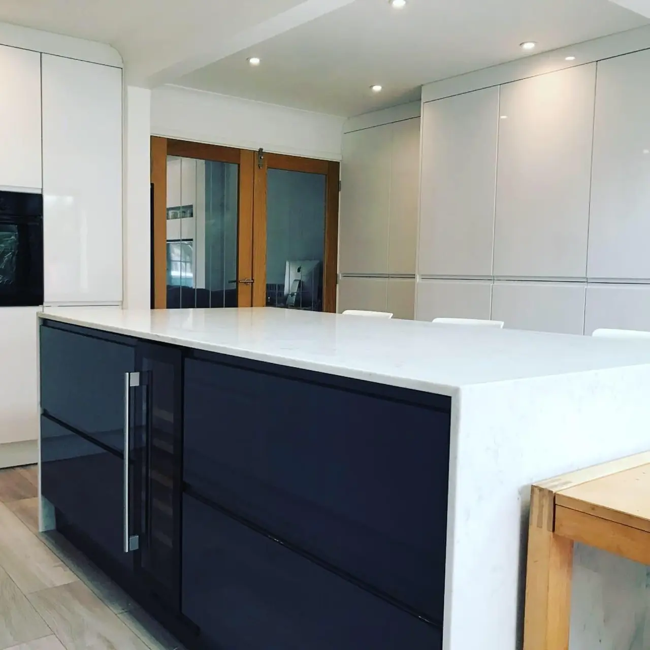 Kitchen navy gloss island mirrored door, made and fitted by Sussex Design Interiors