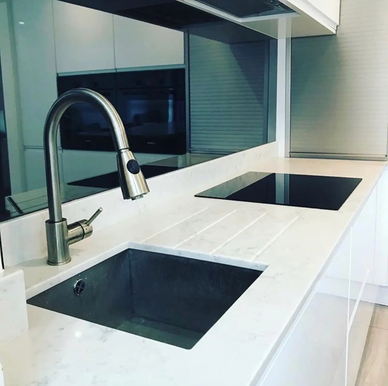 Kitchen white gloss black sink marble island close-up, made and fitted by Sussex Design Interiors