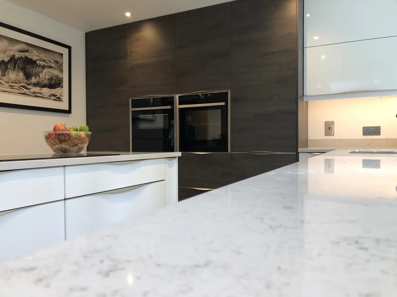 Kitchen white island dark wood ovens close-up, made and fitted by Sussex Design Interiors