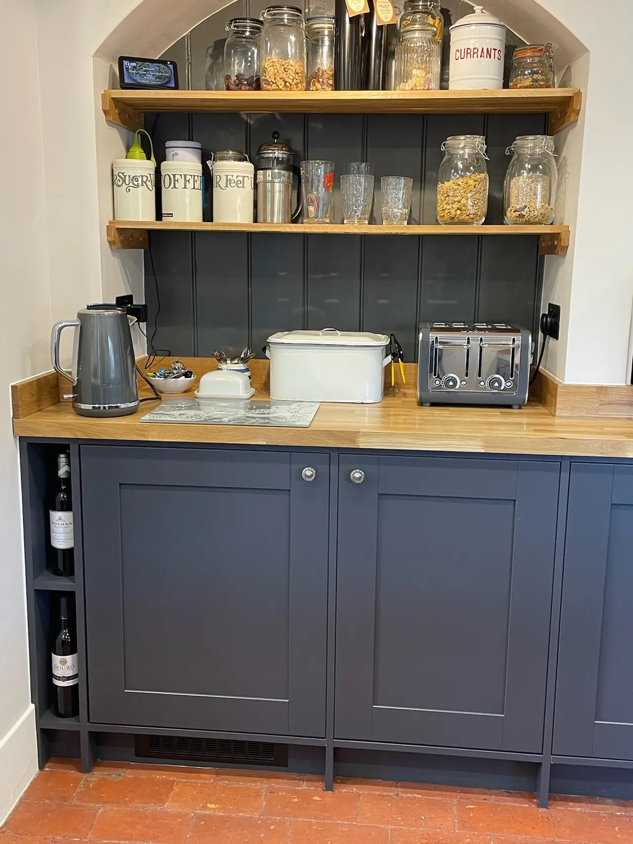 Navy shaker pantry with open shelves stacked with jars