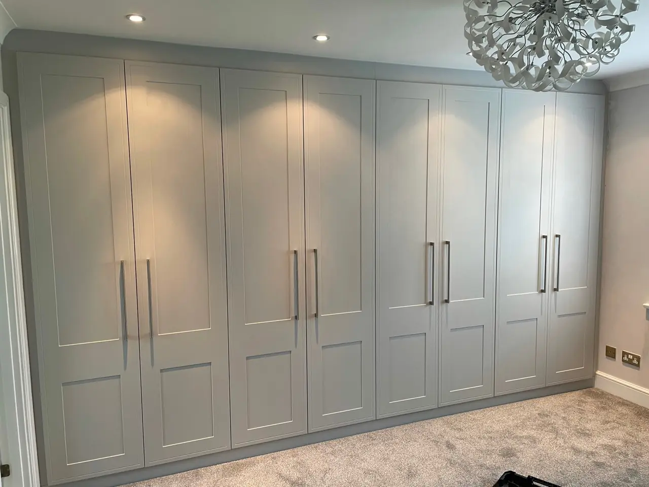 Wardrobe light grey shaker hinged doors chandelier, made and fitted by Sussex Design Interiors